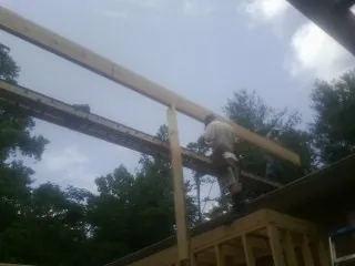 Carpenter setting a ridge beam over a new addition frame — Ice Dam Removal by Roofing Brothers in Gillsville