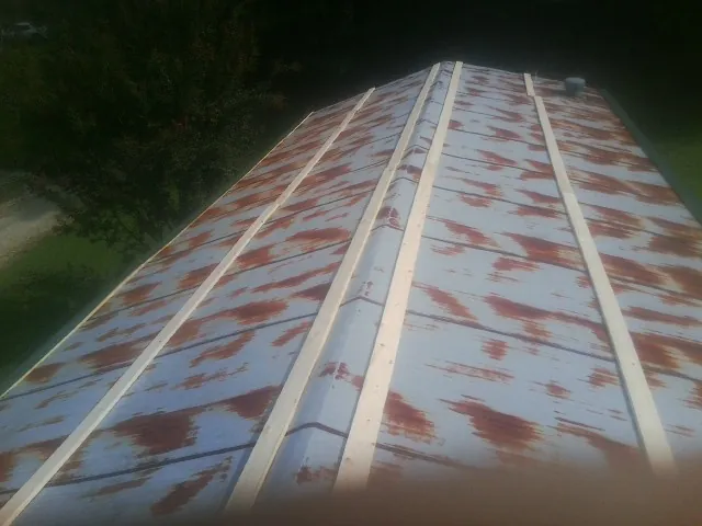 Rusted metal roof panels with new wood purlins before replacement — Storm Damage Roof Repair in Gillsville by Roofing Brothers