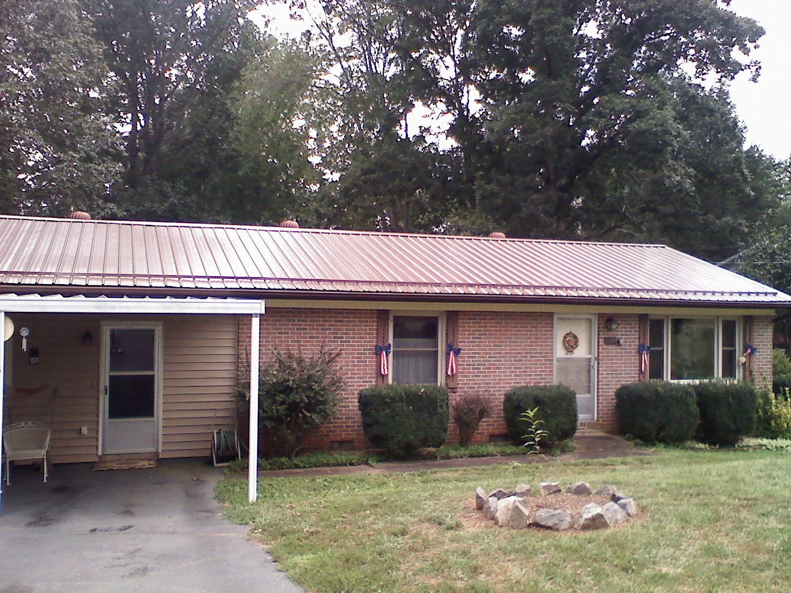 Bronze metal roof and carport on a brick ranch home — Roof Repair work by our crew in Gillsville